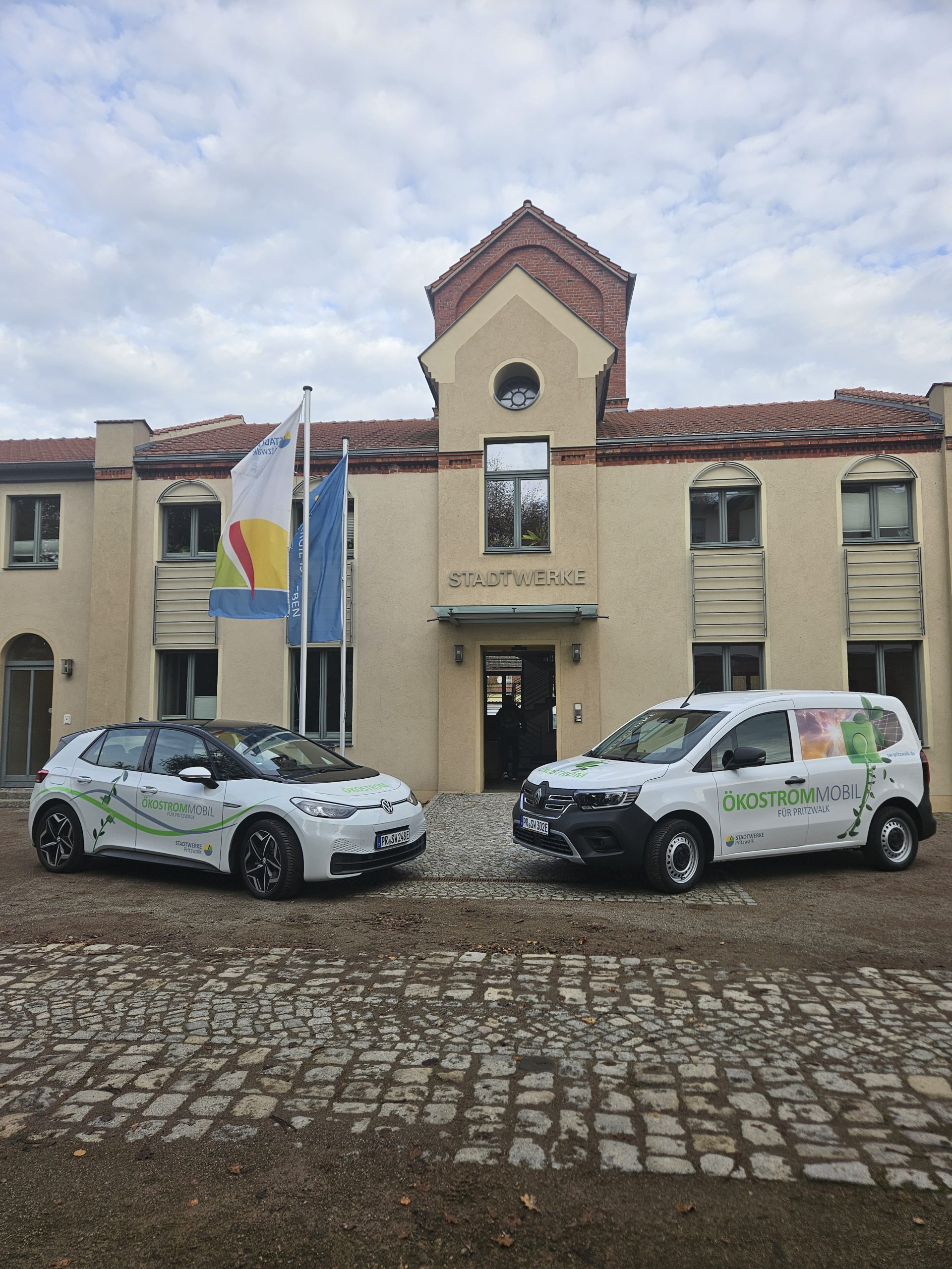 Zwei E-Autos stehen vor dem Eingang des Gebäudes der Stadtwerke Pritzwalk