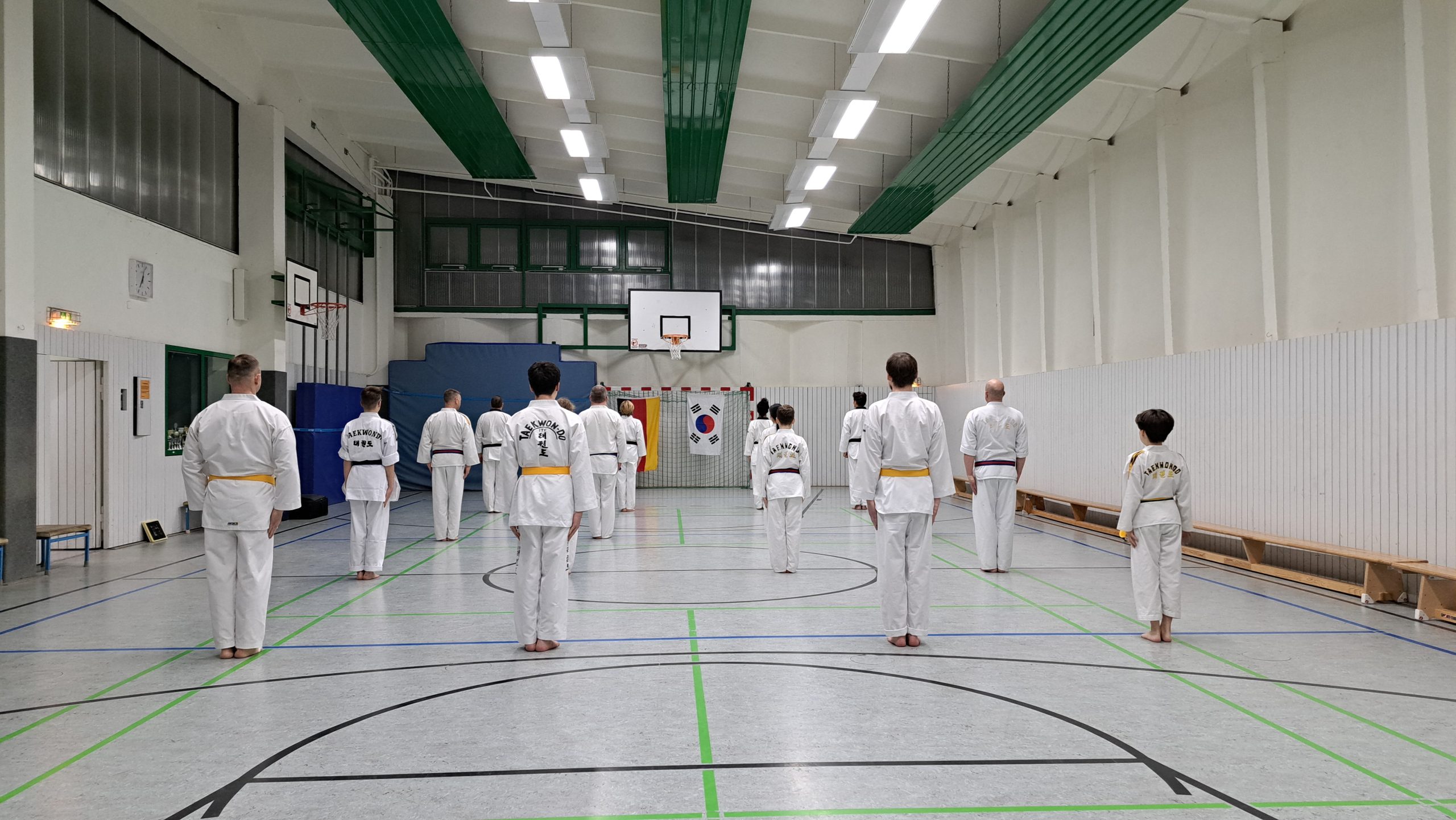 Eine Gruppe steht in einer Sporthalle in Pritzwalk und macht Taekwondo.